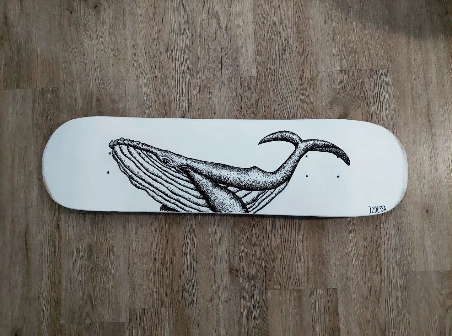 Baleine en pointillisme noir et blanc sur planche de skate